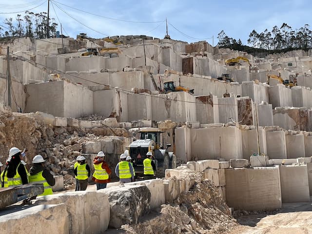 Clientes internacionales visitando una cantera de piedra natural en Portugal durante el evento FRAVIZEL ON para conocer la maquinaria trabajando en condiciones reales.
